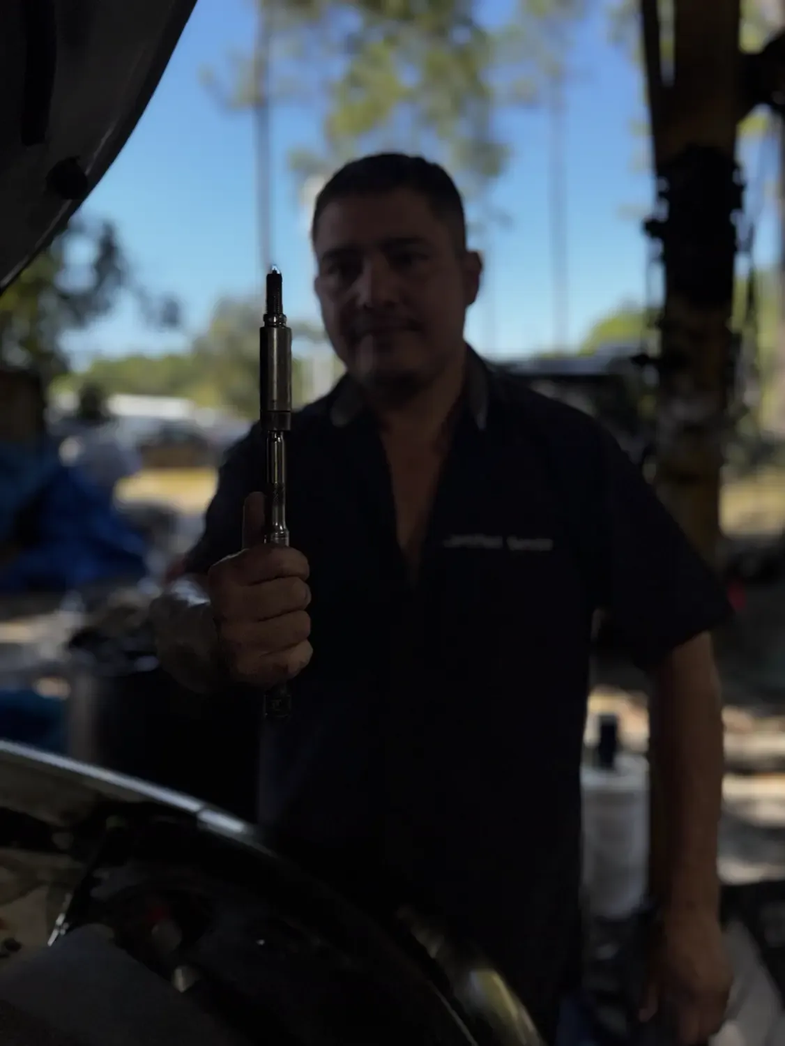 Technician holding a tool in an outdoor work area